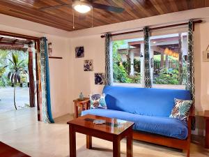 库尔克岛Palmetto Garden Cottage的客厅设有蓝色沙发,配有窗户