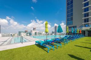 迈阿密Luxury Waterfront Residences - near Kaseya Center的游泳池旁一排带遮阳伞的躺椅