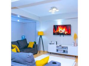 KisiiCH Deluxe Apartments Kisii的客厅配有沙发和墙上的电视