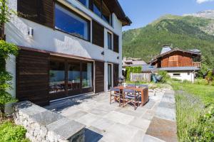 夏蒙尼-勃朗峰Chalet Plein Centre - Savoyard Moderne - Happy Rentals的毗邻大楼的带桌椅的天井