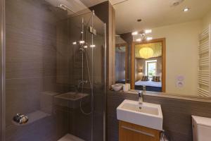 夏蒙尼-勃朗峰Chalet Plein Centre - Savoyard Moderne - Happy Rentals的带淋浴、盥洗盆和镜子的浴室