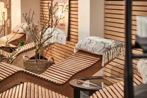 霍森斯Scandic Opus Horsens的阳台配有木制座椅、桌子和盆栽植物