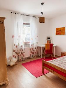 EbernFerienhaus Taeffner的一间卧室配有桌子和红色椅子