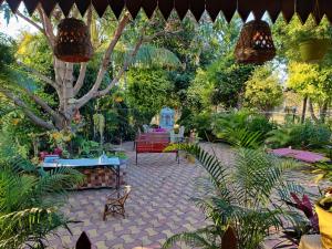 MansarMahuli Agro Tourism的花园,种有长凳和树木及植物