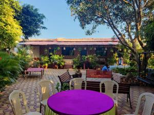 MansarMahuli Agro Tourism的大楼前的紫色桌子和椅子