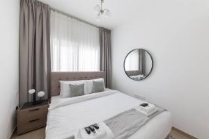 迪拜Comfortable 2bd Apartment Next To Metro & Mall的白色卧室配有床和镜子