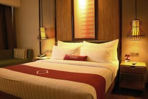 BatusangkarEmersia Hotel & Resort Batusangkar的酒店客房配有一张带白色枕头的大床