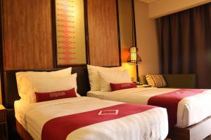 BatusangkarEmersia Hotel & Resort Batusangkar的酒店客房带两张红色和白色的床单