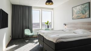谢莱夫特奥Comfort Hotel Skellefteå的一间卧室配有一张大床和一张桌子及椅子