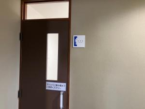Inaiビジネスホテルパークイン石巻的门上挂着标牌,放在房间里