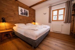 贝旺玫瑰小木屋酒店的木墙客房内的一张大床
