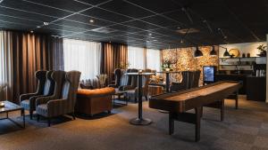 谢莱夫特奥Comfort Hotel Skellefteå的酒吧配有椅子、桌子和钢琴