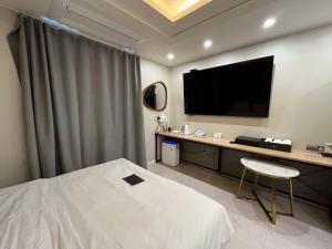 仁川市Carlton Hotel Bupyeong的配有一张床和一台平面电视的酒店客房