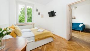 克拉科夫Apartamenty Sun & Snow Basztowa的白色卧室配有床和桌子