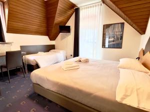 罗恩佐Hotel Regina del Bosco的酒店客房设有两张床和窗户。
