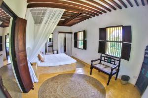 拉穆Pepo Villa, Anasa Hotels & Experiences的一间卧室,卧室内配有一张床和一把椅子