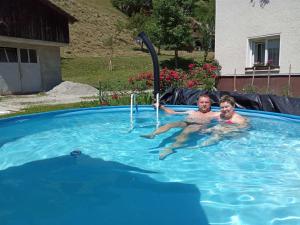 ŽeleznikiDomačija Markc的游泳池里的男人和孩子