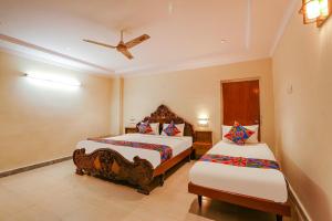 海得拉巴FabHotel Maruthi Residency的一间卧室配有两张床和吊扇