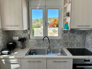 圣加利尼Vrachos Luxury Home 3, private pool!的带水槽的厨房和2扇窗户