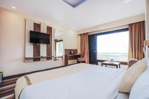 西姆拉Green Valley Resort Mashobra By AN Hotels的一间酒店客房,设有一张大床和一个大窗户