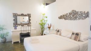 金巴兰Surga Tropical Suites的一间卧室配有一张床、镜子和一张书桌