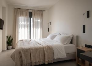 纳夫普利翁ENARIA的白色的卧室设有床和窗户