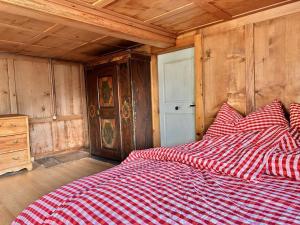 格拉鲁斯Revier Natur pur的一张床上,床上有红白的毯子