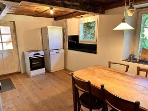 格拉鲁斯Revier Natur pur的厨房配有木桌和冰箱。