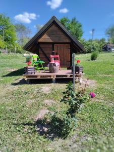 NeštinMini-Camp SKELICA的一个小房子,设有门廊和两把椅子