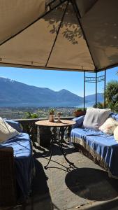 洛迦诺奥兰达膳宿公寓酒店的庭院设有两张床和一张桌子,享有美景。