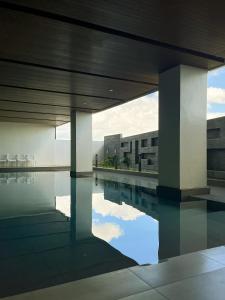 马尼拉Hotel101 - Fort的一座带椅子的游泳池以及一座建筑