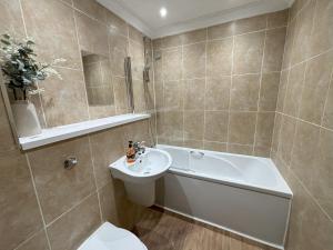 伊斯特布恩Millgrove House Apartments的带浴缸、盥洗盆和卫生间的浴室