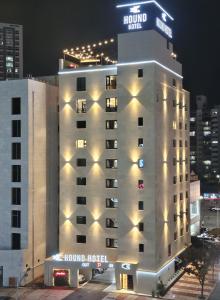 木浦市Hound Hotel Mokpo Peace Plaza的酒店大楼的顶部灯火通明