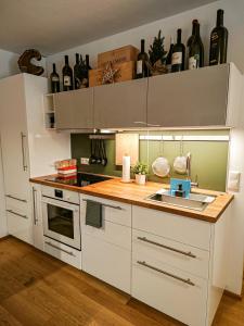 图拉彻霍赫Grünseeappartement的厨房配有白色橱柜和带水槽的台面