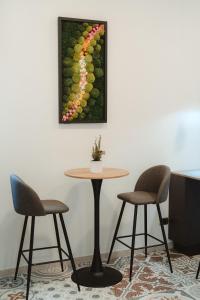 奇维塔韦基亚Lifestyle and Suites的一张桌子,两张椅子和一张葡萄藤的照片