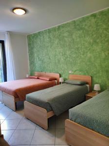 赫拉弗多纳德尔法尔科酒店的一间卧室设有两张床和绿色的墙壁