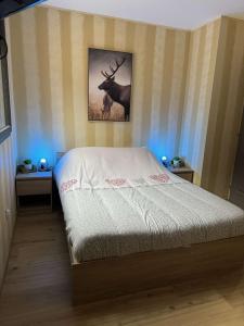 Gerbamont Gîte du Bambi的卧室配有一张床和鹿的照片