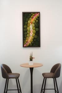 奇维塔韦基亚Lifestyle and Suites的一张桌子、两把椅子和一张墙上的照片