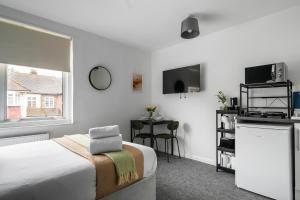 East BarnetLivestay Affordable En-Suite Studio Rooms in London, N14的一间卧室配有一张床、一张桌子和一个窗户。