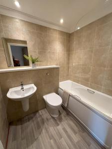 伊斯特布恩Millgrove House Apartments的浴室配有盥洗盆、卫生间和浴缸。
