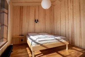 基尔匹斯扎我维Kalamaja Kilpisjärvi的木制客房内的一间卧室,配有一张床