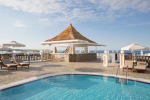 玛利亚Alexander Beach Hotel & Village Resort的一个带凉亭和大海的度假游泳池