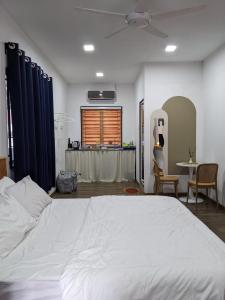 甲抛峇底Rods Homestay - Kg Agong Penaga的卧室配有一张白色的大床和一张桌子