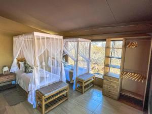 侯斯普瑞特African Dream Tour的一间卧室设有天蓬床和窗户。