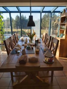 克利夫登Bed & Breakfast - Shanakeever Farm的一张带椅子的长木桌子和大窗户