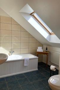 克利夫登Bed & Breakfast - Shanakeever Farm的带浴缸和天窗的浴室