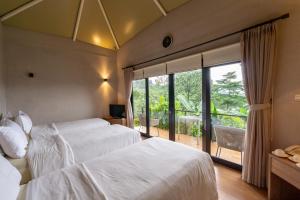 PasirkudaPelangi Park Hotel & Resort的酒店客房设有两张床和大窗户。
