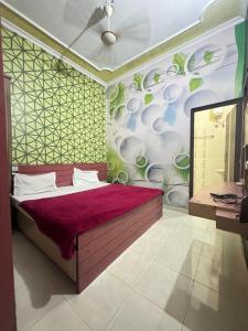 贾朗达尔Hotel Star INN的一间设有一张大床的卧室,位于带绿色墙壁的房间