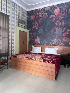 贾朗达尔Hotel Star INN的一间卧室配有一张带花卉壁纸的大床
