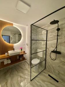 布什泰尼Pensiunea Liziera的带淋浴、盥洗盆和镜子的浴室